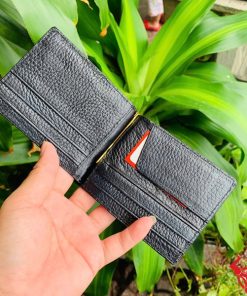 Hình ảnh ví kẹp tiền da cá sấu gai tay đen VOA5, thiết kế sang trọng, cầm trên tay trước nền lá xanh tự nhiên.