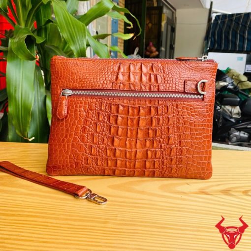 Clutch cầm tay da cá sấu nâu đỏ, biểu tượng thời trang quý ông.