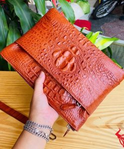 Clutch cầm tay nam da cá sấu nâu đỏ, phong cách hiện đại.
