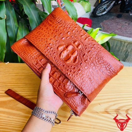 Clutch cầm tay nam da cá sấu nâu đỏ, phong cách hiện đại.