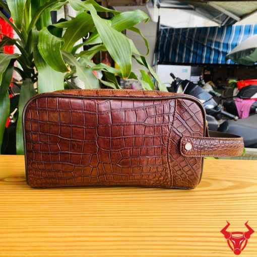 Chiếc clutch da cá sấu nâu đất, thể hiện thời trang và đẳng cấp cổ điển.