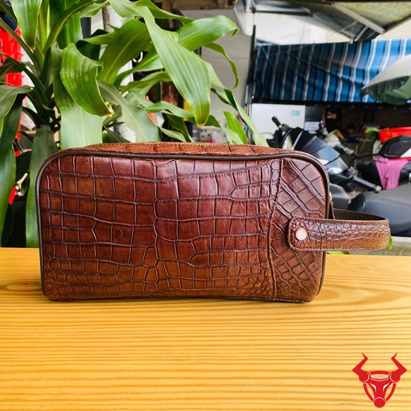 Chiếc clutch da cá sấu nâu đất, thể hiện thời trang và đẳng cấp cổ điển.