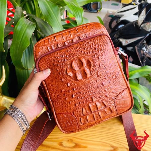 Hình ảnh túi đeo chéo nam da cá sấu nâu đỏ, bền bỉ, sang trọng, đẳng cấp thời trang.