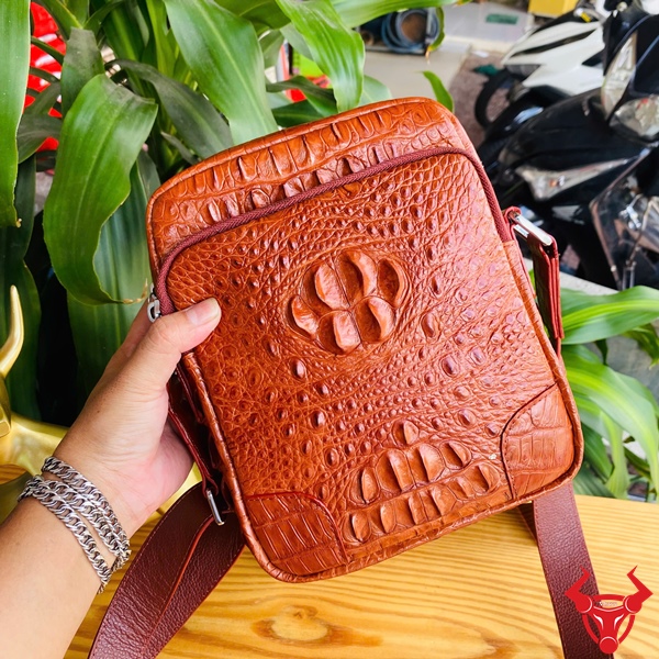 Đẳng cấp và bền bỉ với TVA4 Hình ảnh túi đeo chéo nam da cá sấu nâu đỏ, bền bỉ, sang trọng, đẳng cấp thời trang.