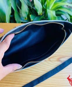 Hình ảnh túi đeo chéo da cá sấu gù HM-17 màu đen trắng, đặt trên bàn gỗ, thể hiện phong cách thời trang sang trọng.