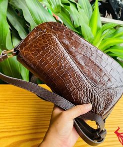 Hình ảnh túi đeo vai da cá sấu HM-20 màu nâu, đặt trên bàn gỗ, thể hiện phong cách sang trọng và cá tính.