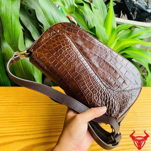 Hình ảnh túi đeo vai da cá sấu HM-20 màu nâu, đặt trên bàn gỗ, thể hiện phong cách sang trọng và cá tính.