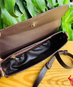 Hình ảnh túi đeo vai da cá sấu HM-20 màu nâu, đặt trên bàn gỗ, thể hiện phong cách thời trang sang trọng và cá tính.