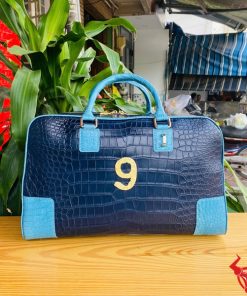 Túi xách du lịch da cá sấu phối xanh navy và xanh dương nổi bật, tay cầm chắc chắn.