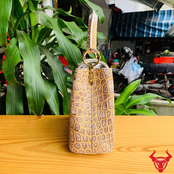 Túi Da Cá Sấu Bạch Tạng - Đẳng Cấp Sang Trọng Hình ảnh túi xách da cá sấu bạch tạng nhũ vàng, đặt trên bàn gỗ, nổi bật với phong cách quý phái và đẳng cấp.