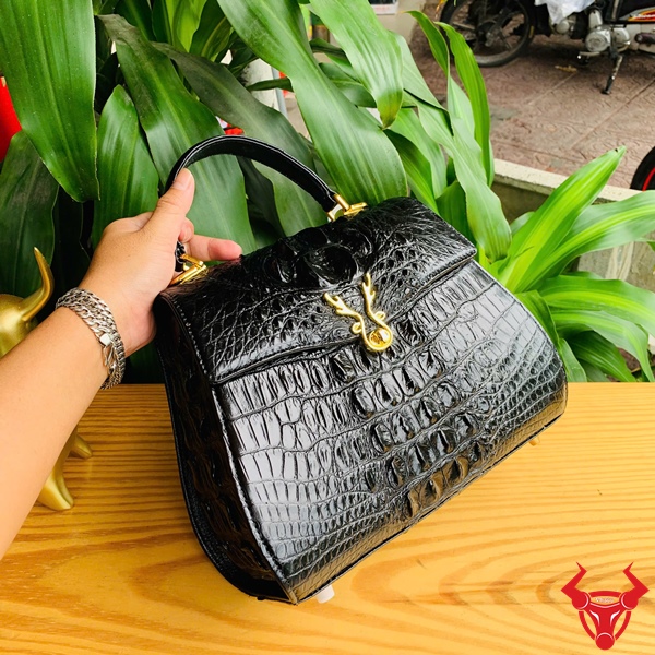 Phong cách quý tộc cùng túi da cá sấu HM-1 chất lượng Hình ảnh túi HM-1, da cá sấu đen sang trọng, mặt khóa nai nổi bật.