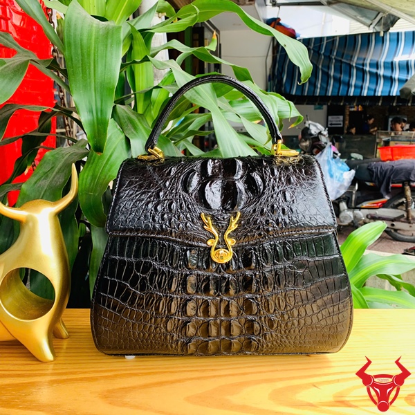 Thời trang sang trọng với túi da cá sấu HM-1 mặt khóa nai Hình ảnh túi xách HM-1, da cá sấu đen sang trọng, mặt khóa nai cá tính.