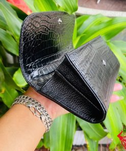 ận cảnh ví nữ da bụng cá sấu đen với đường chỉ may chắc chắn.
