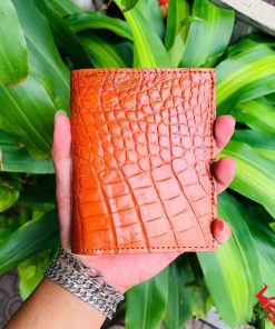 Một chiếc ví da cá sấu màu đỏ sang trọng, thiết kế thời trang, thể hiện đẳng cấp và phong cách cao cấp.