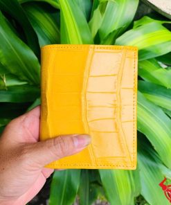 Một chiếc ví da bụng cá sấu màu vàng nổi bật, thiết kế thời trang, thể hiện đẳng cấp và phong cách cao cấp.