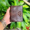 Một chiếc ví da cá sấu nguyên con màu nâu đất sang trọng, thiết kế thời trang, thể hiện đẳng cấp và phong cách cao cấp.