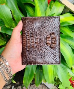Một chiếc ví da cá sấu nguyên con màu nâu đất sang trọng, thiết kế thời trang, thể hiện đẳng cấp và phong cách cao cấp.
