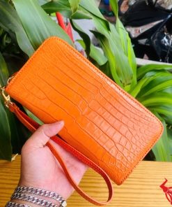 Ví da cam có khóa kéo vàng, phong cách trẻ trung, nổi bật.
