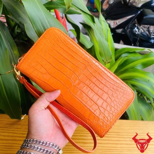 Ví da cam có khóa kéo vàng, phong cách trẻ trung, nổi bật.