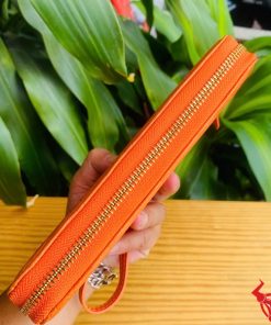 Ví da bụng cá sấu thật màu cam ánh bóng, chi tiết khóa zip.