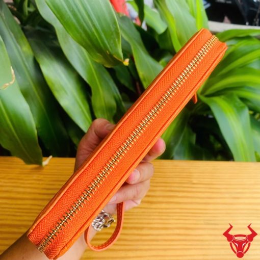 Ví da bụng cá sấu thật màu cam ánh bóng, chi tiết khóa zip.