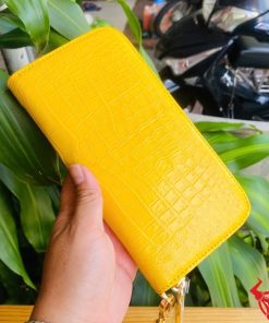 Ví vàng da cá sấu thật, sắc màu nổi bật dưới ánh sáng tự nhiên.