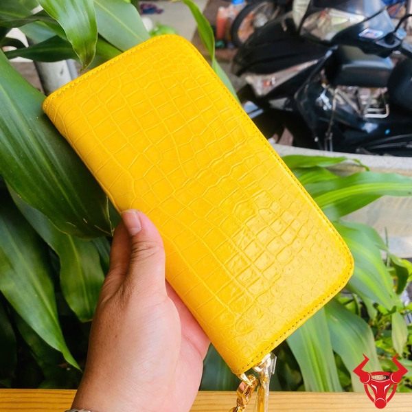 Ví Cầm Tay Da Cá Sấu Vàng – Phụ Kiện Thời Trang Cao Cấp Ví vàng da cá sấu thật, sắc màu nổi bật dưới ánh sáng tự nhiên.