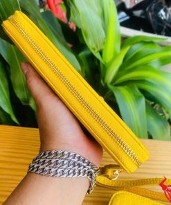 Cận cảnh ví da cá sấu vàng có khóa kéo kim loại bền chắc.