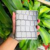 Chiếc ví form đứng da cá sấu trắng phối vân đen, biểu tượng của sự cao cấp và thời trang.