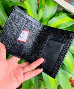 Ví da thật gai lưng cá sấu, màu đen lịch lãm giữa nền cây xanh.