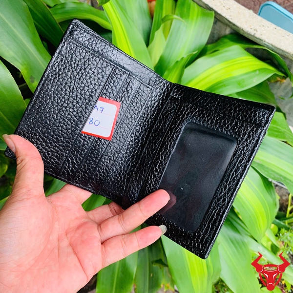 Ví da thật gai lưng cá sấu, màu đen lịch lãm giữa nền cây xanh.