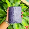Một chiếc ví nam form đứng da cá sấu màu xanh navy, thể hiện phong cách thời trang cao cấp và đẳng cấp.