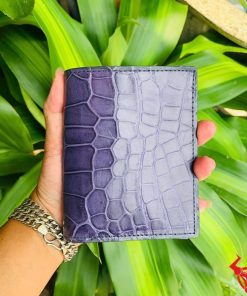 Một chiếc ví nam form đứng da cá sấu màu xanh navy, thể hiện phong cách thời trang cao cấp và đẳng cấp.