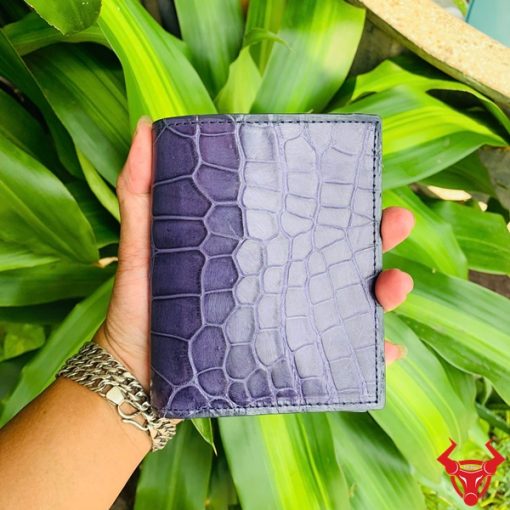 Một chiếc ví nam form đứng da cá sấu màu xanh navy, thể hiện phong cách thời trang cao cấp và đẳng cấp.