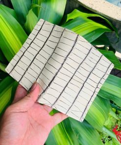 Ví da cá sấu trắng với đường vân đen, cầm trên tay người đeo vòng bạc.