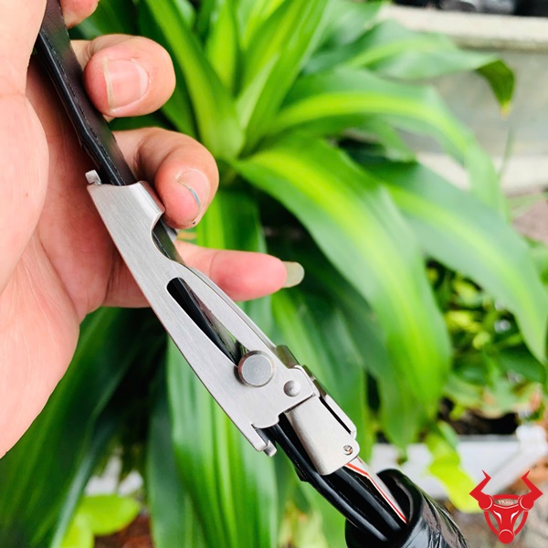 Thắt Lưng Sang Trọng Da Cá Sấu TSK32 Hình ảnh thắt lưng TSK32 màu đen, da cá sấu sang trọng, mặt khóa lăn inox, cầm trên tay với cây xanh phía sau.