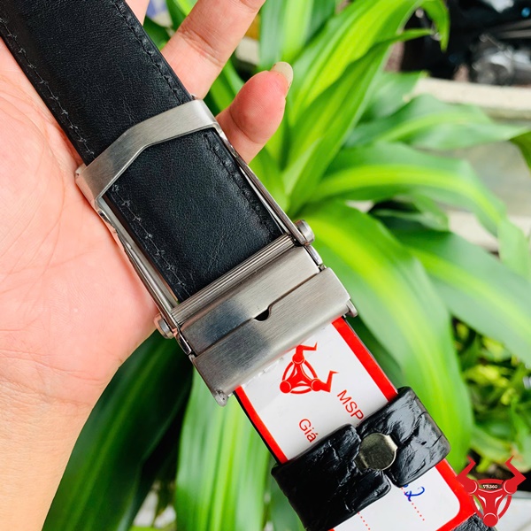 Đỉnh cao thời trang - Thắt Lưng Da Cá Sấu TSK32 Hình ảnh thắt lưng TSK32 màu đen, da cá sấu sang trọng, mặt khóa lăn inox, cầm trên tay với nền cây xanh.