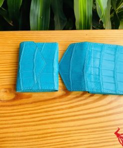 Hình cầm ba ví mini da cá sấu VRAA8 3 gấp màu xanh, nền xanh tươi, thể hiện thời trang, phong cách nhỏ gọn cho phụ nữ.